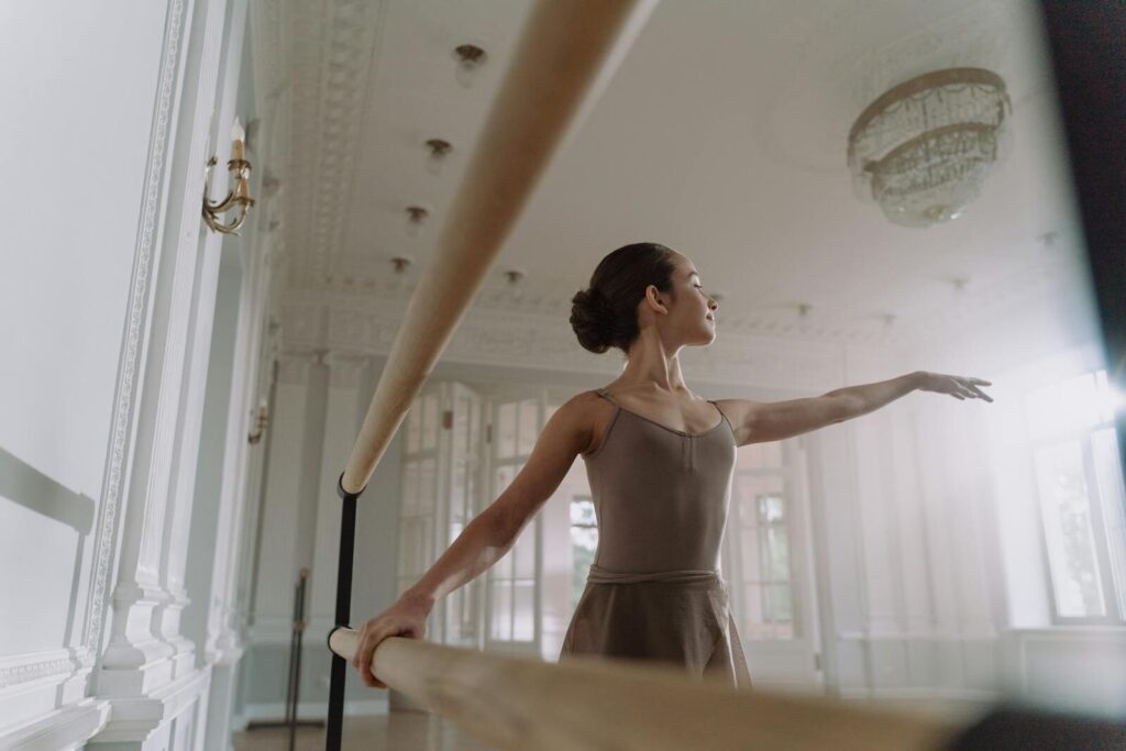 Graceful ballerina practicing in a light-filled studio, showcasing elegance and poise during training.